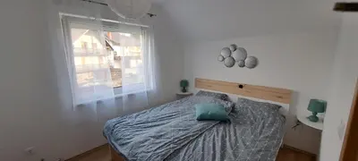 a bedroom with a bed with a blue pillow on it at Apartma Bine in Bled