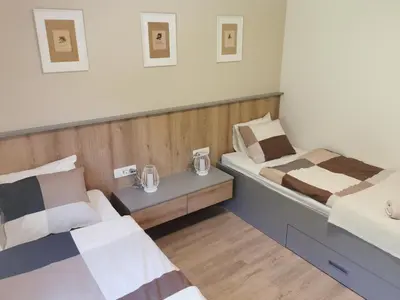 a room with two beds and a nightstand between them at Apartma Bella Nadiža in Kobarid