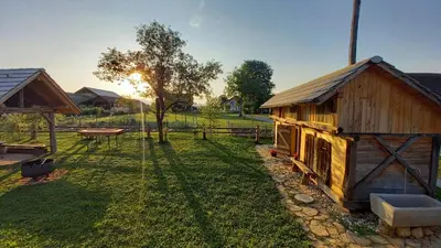 a wooden cabin in a yard with a picnic table at Pig barn - Svinjaki in Krasinec
