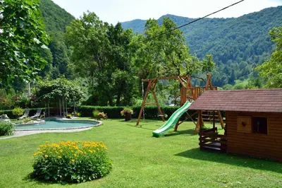 a backyard with a slide and a playground at Apartment Sotočje in Dolenja Trebuša
