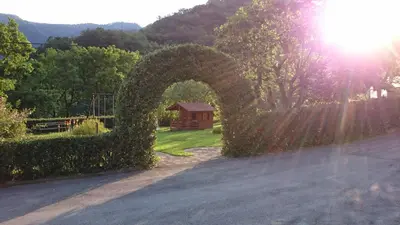 an arch of ivy over a driveway with a house at Apartment Sotočje in Dolenja Trebuša