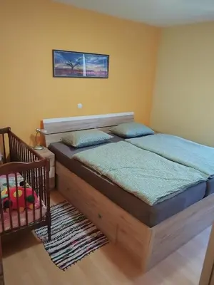 a bedroom with a bed and a crib at Apartma Julia in Spodnje Gorje