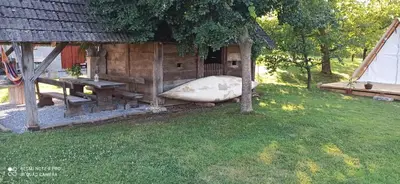 a wooden house with a boat in a yard at Na vrtu K25 in Gradac