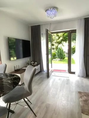 a living room with a table and chairs and a television at Luxury Apart near Lake Bohinj in Bohinj