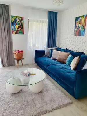 a living room with a blue couch and a glass table at Luxury Apart near Lake Bohinj in Bohinj