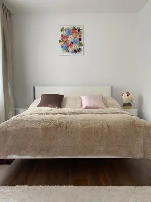 a white bedroom with a large bed with two pillows at Luxury Apart near Lake Bohinj in Bohinj