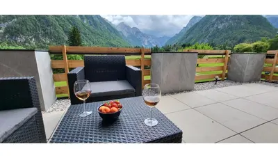 two glasses of wine and a bowl of fruit on a table at Počitniška hiša pr Puc in Mojstrana