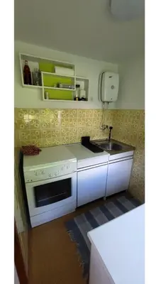 a kitchen with a white stove and a sink at Počitniška hiša pr Puc in Mojstrana