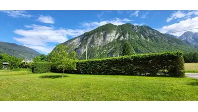 a view of a mountain with a green grass field at Počitniška hiša pr Puc in Mojstrana