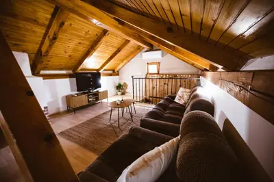a living room with a couch and a tv at Počitniška hiša Car in Dobrovnik