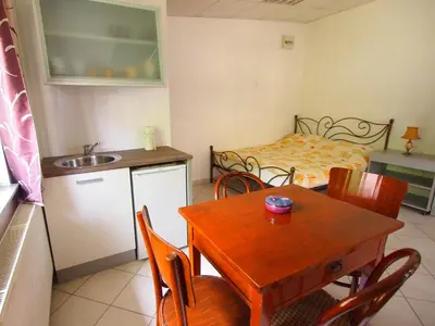 a kitchen and dining room with a table and a bed at In the Center of Rogaška Slatina! Apartment Fani and Studio Marija in Rogaška Slatina