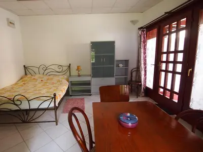 a bedroom with a bed and a table and a dining room at In the Center of Rogaška Slatina! Apartment Fani and Studio Marija in Rogaška Slatina
