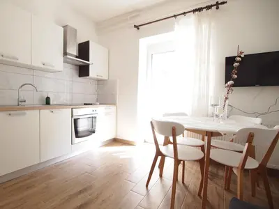 a white kitchen with a dining room table and chairs at In the Center of Rogaška Slatina! Apartment Fani and Studio Marija in Rogaška Slatina