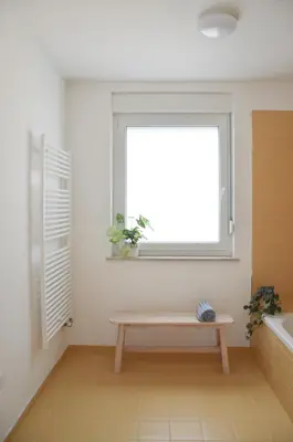 a bathroom with a bench in front of a window at STUDIO GREENHOUSE in Tolmin