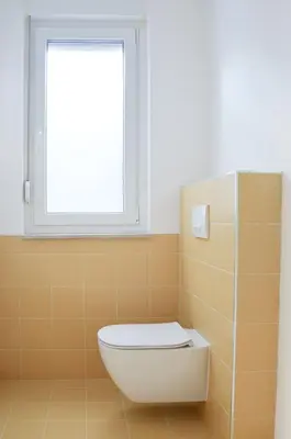 a bathroom with a toilet and a window at STUDIO GREENHOUSE in Tolmin