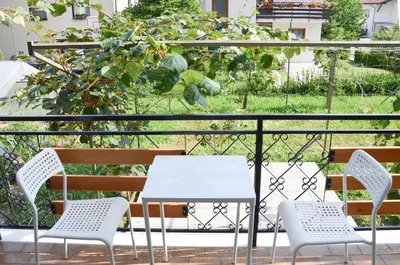 a white table and chairs on a balcony at STUDIO GREENHOUSE in Tolmin