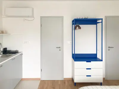 a kitchen with a white cabinet with a blue door at STUDIO GREENHOUSE in Tolmin