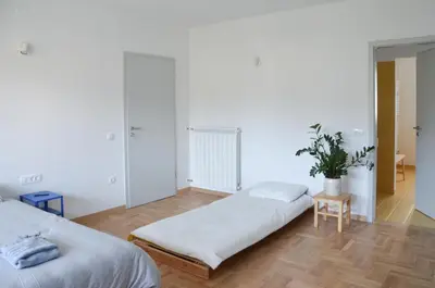a bedroom with two beds and a potted plant at STUDIO GREENHOUSE in Tolmin