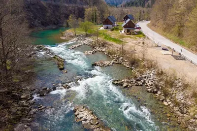 a river next to a road and a house at Riverside Resort Stari Malni Kolpa in Osilnica