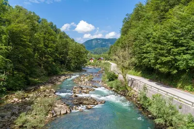 a river in the mountains with a road at Riverside Resort Stari Malni Kolpa in Osilnica