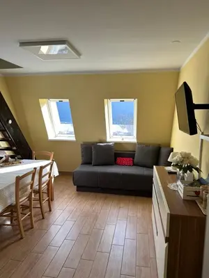 a living room with a couch and a table at BovecEnter Apartments Kaninska vas in Bovec