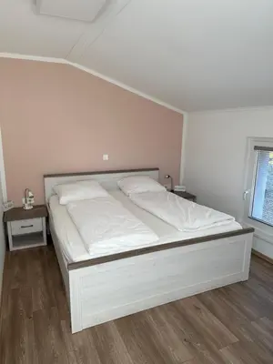 a white bed in a room with two night stands at BovecEnter Apartments Kaninska vas in Bovec