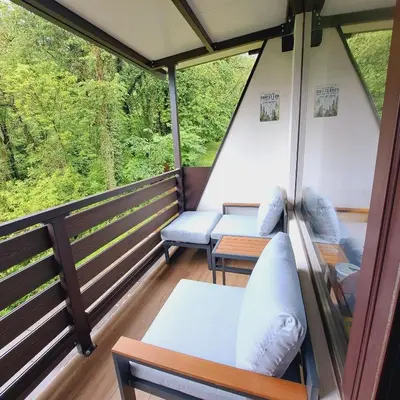 a balcony with couches and tables on a train at BovecEnter Apartments Kaninska vas in Bovec