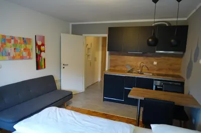 a living room with a couch and a kitchen at BovecEnter Apartments Kaninska vas in Bovec