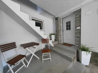 a stairway with two chairs and a door at Apartma Bela in Bohinjska Bela