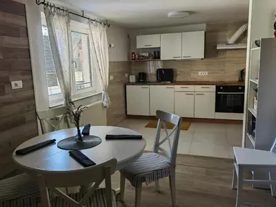 a kitchen with a table and chairs in a room at Apartma Bela in Bohinjska Bela