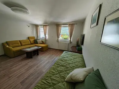 a living room with a couch and a living room with at Apartma Bela in Bohinjska Bela