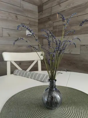 a vase with purple flowers sitting on a table at Apartma Bela in Bohinjska Bela