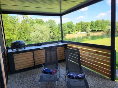 a screened in porch with two chairs and a large window at KOLPA - Luxury Natura House in Gradac