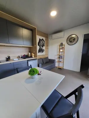 a kitchen and living room with a white table and chairs at KOLPA - Luxury Natura House in Gradac