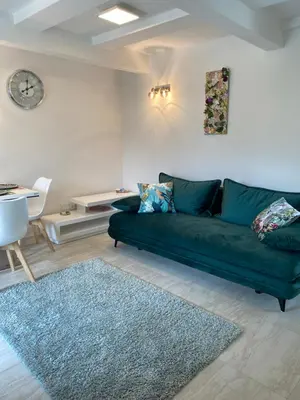 a living room with a green couch and a table at Mountain view in Bohinj in Bohinj
