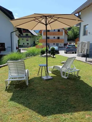 two chairs and a table under an umbrella at Mountain view in Bohinj in Bohinj