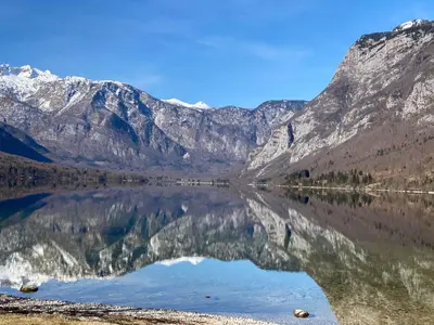 a reflection of the mountains in a lake at Mountain view in Bohinj in Bohinj