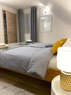 a bed with a gray comforter and yellow pillows at Mountain view in Bohinj in Bohinj