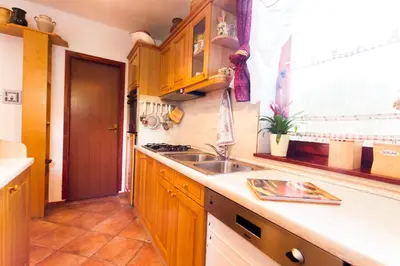 a kitchen with wooden cabinets and a sink and a window at Holiday Home Juričko with private Sauna in Bizeljsko