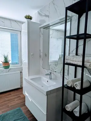 a white bathroom with a sink and a mirror at Domen's cozy rentals in Kranj