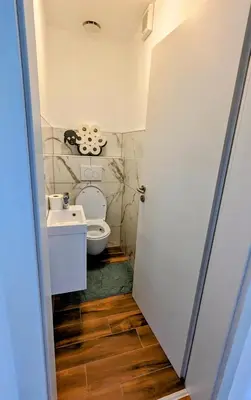 a bathroom with a toilet and a sink at Domen's cozy rentals in Kranj