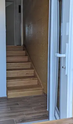a stairwell with wooden stairs in a building at Domen's cozy rentals in Kranj
