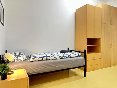 a bedroom with a bed and a wooden cabinet at Railway Ljubljana ROOMS in Ljubljana
