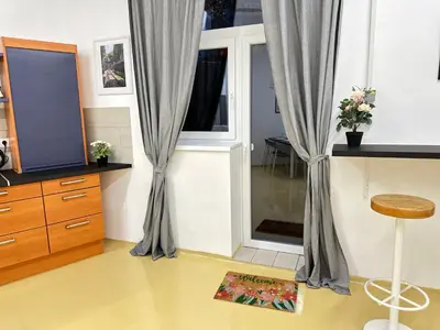 a room with a window with curtains and a stool at Railway Ljubljana ROOMS in Ljubljana