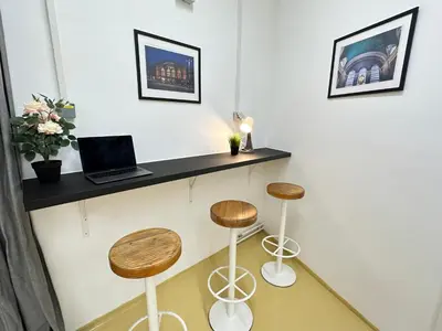 a counter with two stools and a laptop on a wall at Railway Ljubljana ROOMS in Ljubljana