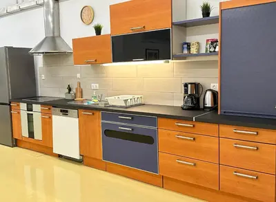 a kitchen with wooden cabinets and a stove top oven at Railway Ljubljana ROOMS in Ljubljana