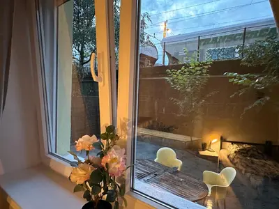 a window with two chairs and a vase with flowers at Railway Ljubljana ROOMS in Ljubljana