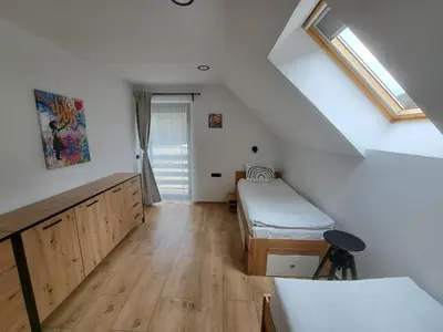 a attic room with two beds and a window at Riverside Apartma 1, Kranjska Gora in Kranjska Gora