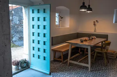 a dining room with a table and a window at Kotič na hribu in Dobravlje