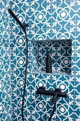 a bathroom with a blue and white tiled wall at Kotič na hribu in Dobravlje